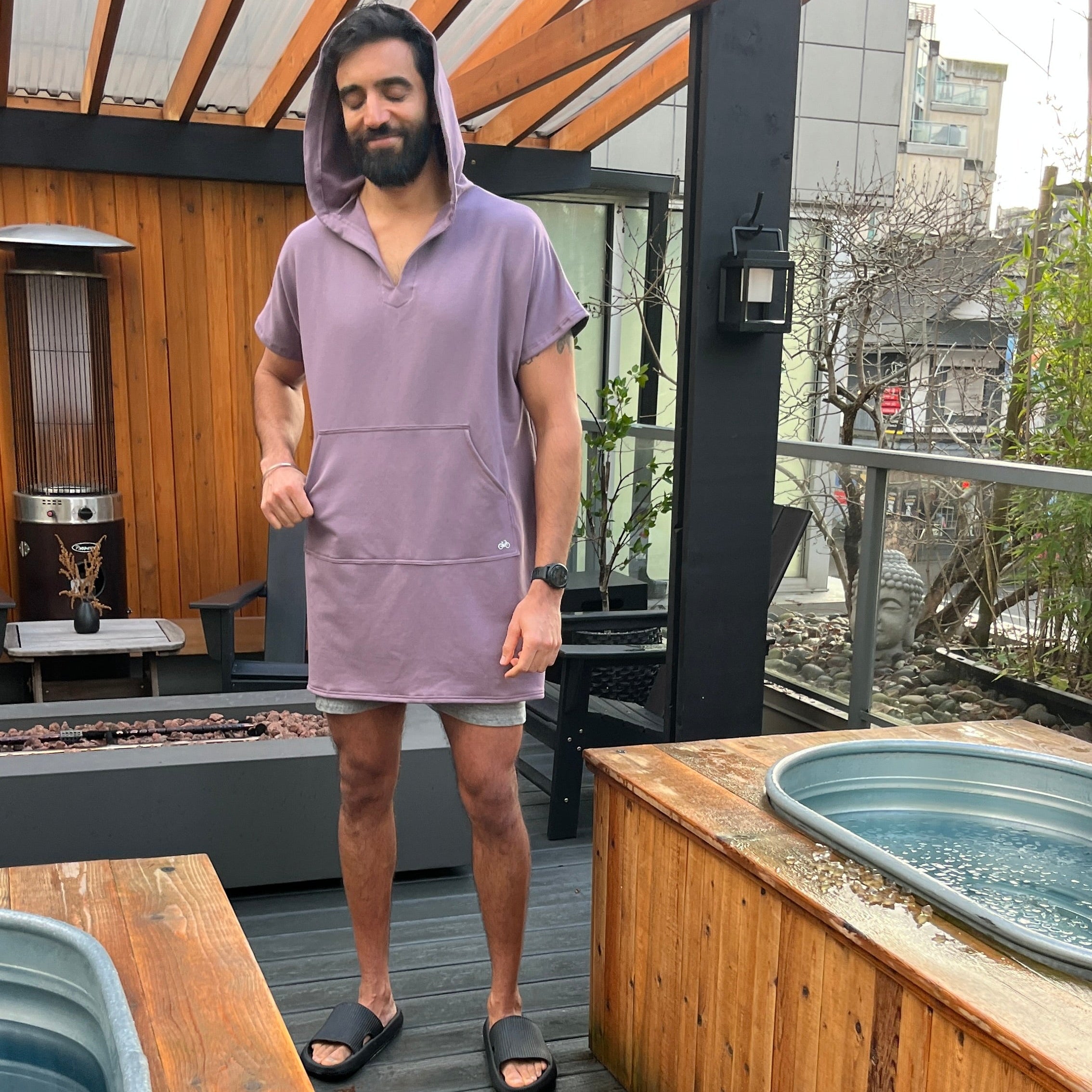 Man standing on a wooden deck around cold plunge tubs with a modern architectural design