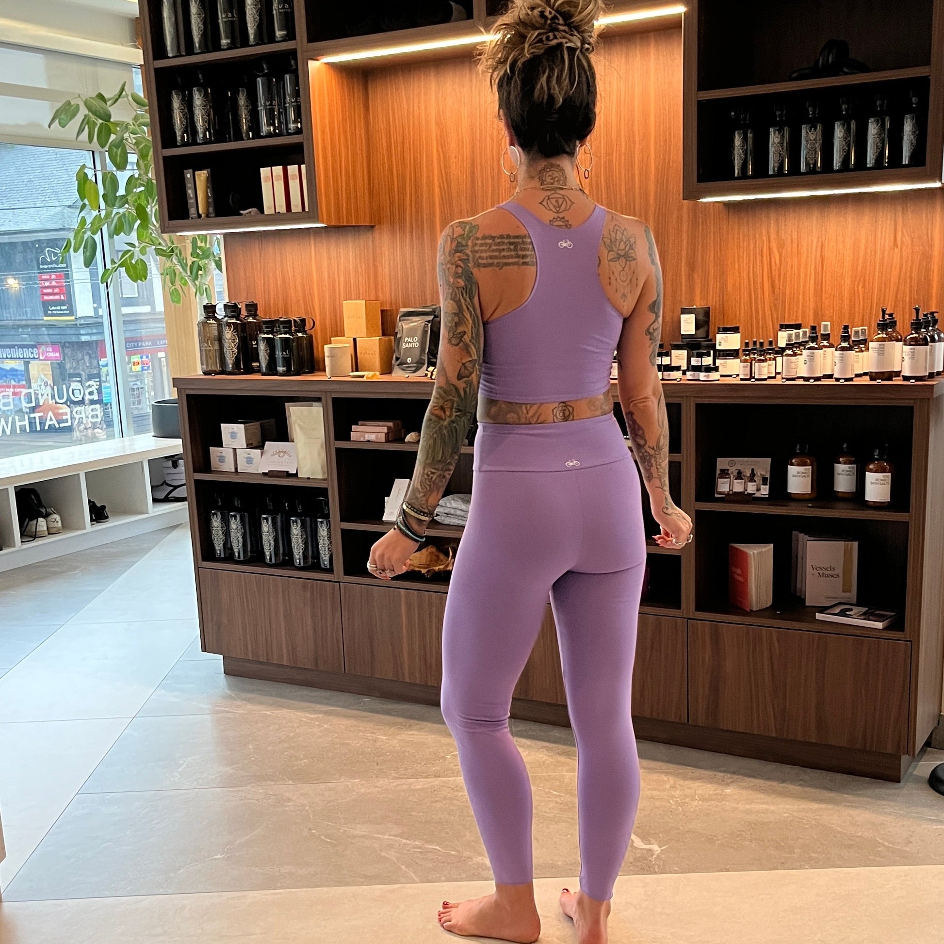 Person wearing a purple athletic outfit standing in a modern interior setting.
