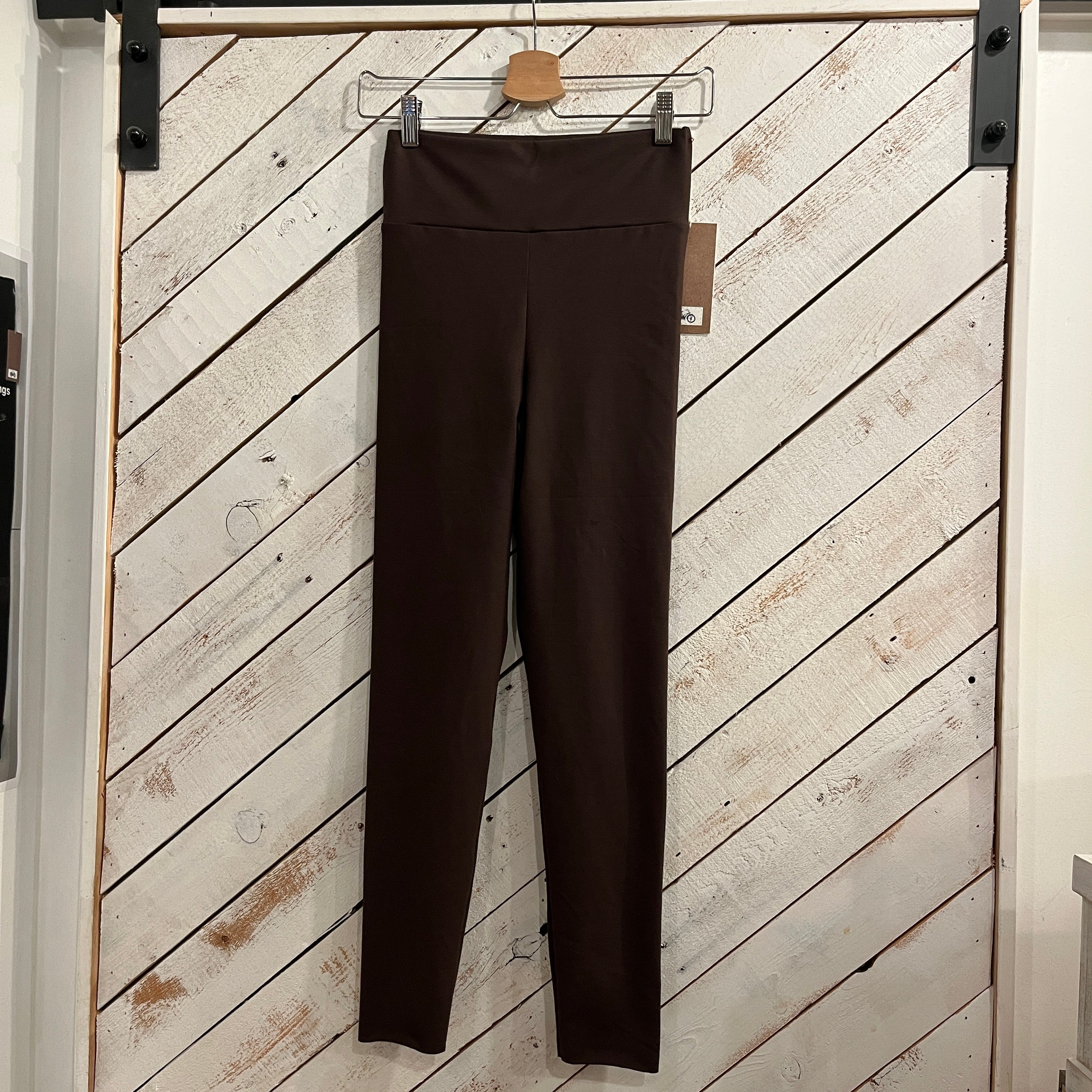 Dark Brown Leggings hanging on a white wooden sliding barn door