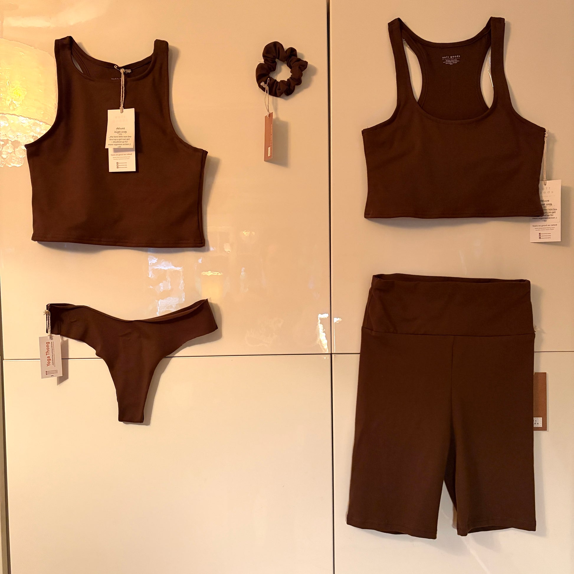 Brown tank top, shorts, and underwear displayed on a tiled wall.